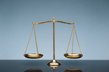 平等化蓝色背景上的平衡刻度照片