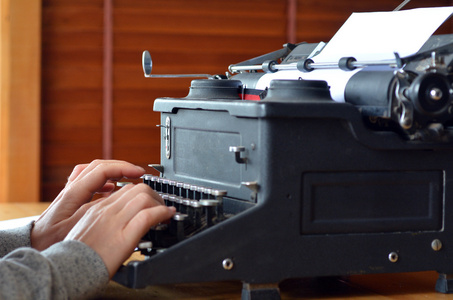 年轻的女作家，在老式打字机上写的手