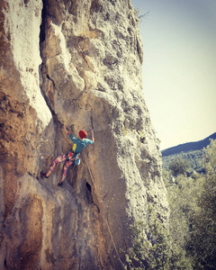 女子攀岩。攀岩爬上岩壁。女人让勤奋动