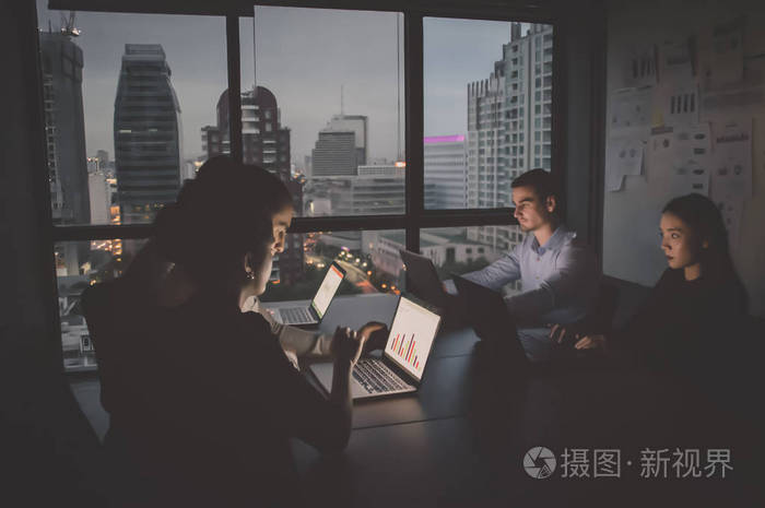 一群在夜间加班的商务人员.商人们对办公室工作很认真.