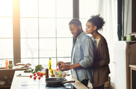 爱的非洲裔美国人夫妇在阁楼厨房烹饪