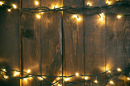节日圣诞节粗糙木材背景与灯花环