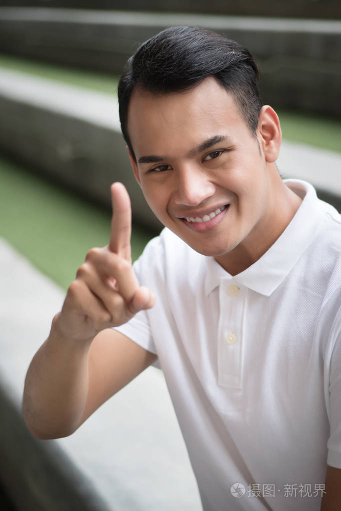 快乐的人指着一个手指手势;微笑友好的人显示批准, 建议1手指;快乐的