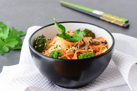 胡萝卜 西兰花和蘑菇在黑色的抽象背景上的黑色碗米粉。亚洲食品。健康的食物