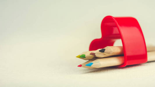 彩色铅笔躺在红色的心形符号和绘图的创造力代表爱