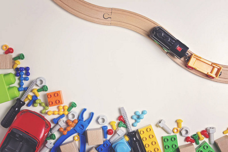 五颜六色的儿童玩具 塑料玩具工具 螺栓 螺母 车 训练与作为框架的白色背景上的木栏杆。顶视图