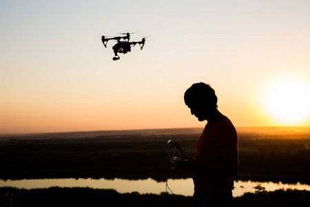 无人机的剪影, quadrocopter 与相片照相机在天空飞行