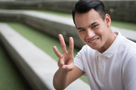 印度数钱的家伙快乐的人指着三指手势;微笑友好的人指向3数字, 数字三