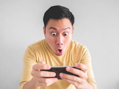 震惊亚洲人玩手机游戏在他的智能手机照片