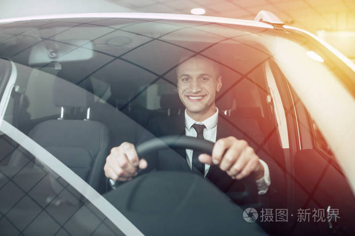 愉快的商人在西装驾驶汽车