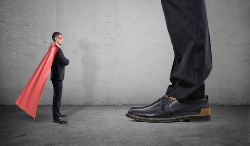 一个小商人在超人披风站用脚只看到面对巨人照片