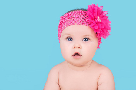 可爱的宝宝，与粉红色的蝴蝶结在头上，花上蓝色孤立