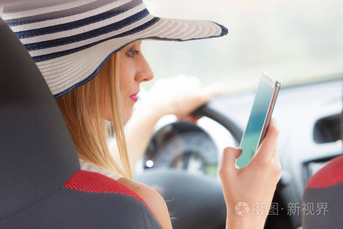 她开车时使用手机的女人照片-正版商用图片0opfjt-摄图新视界