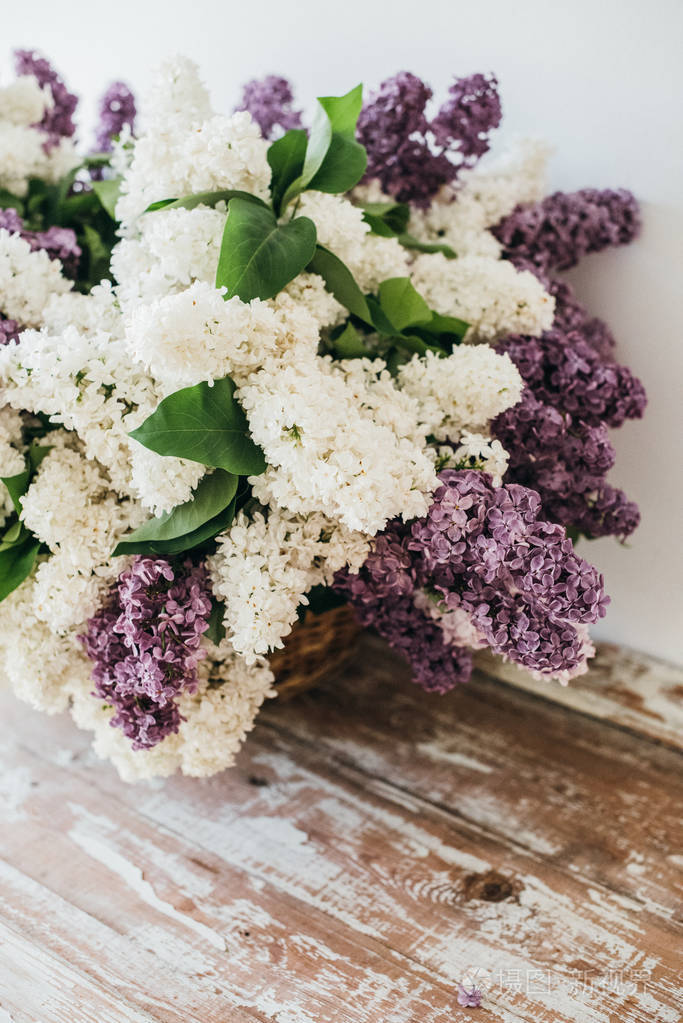 在ta的柳条篮子里的白色和紫色的丁香花花束