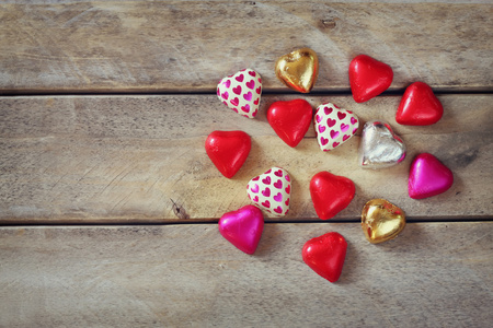 顶视图图像的多彩的心形状巧克力木制的桌子上。情人节那天庆祝概念