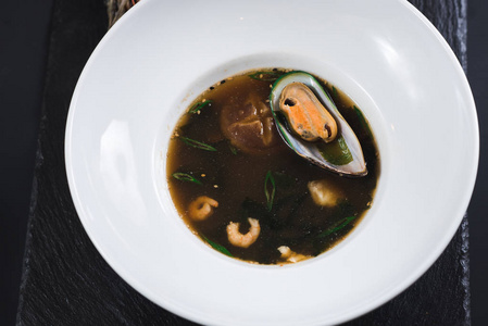 从海鲜和蘑菇到黑色背景的美味汤