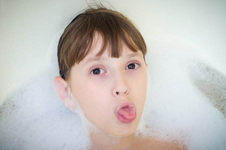 躺插要动态女孩躺在一间浴室,泡沫和伸出舌头照片