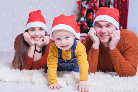 幸福的家庭，在圣诞节前夕在装饰树附近坐在一起