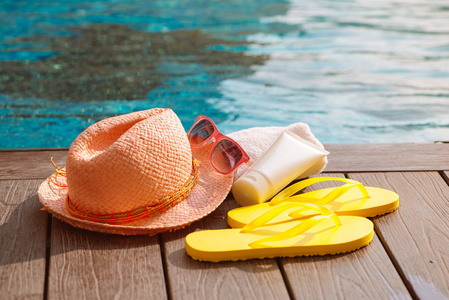 泳池边的帽子太阳镜和防晒霜, 夏季旅游概念