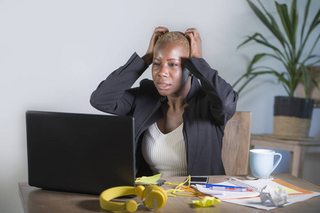 压力和沮丧的美国黑人妇女工作不堪重负和不安在办公室膝上型电脑办公桌上示意悲伤和绝望的压力看起来累了业务和工作问题