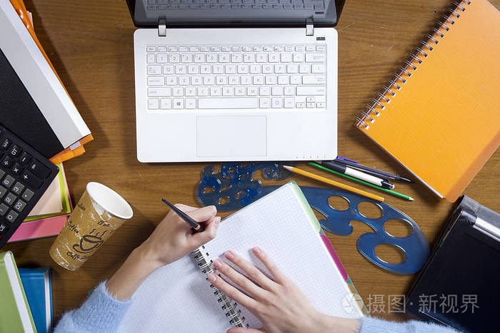 女性双手在笔记本电脑上写字