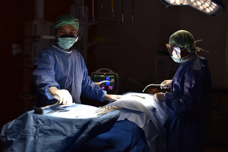 在手术室里工作的团队医生。手术室里的手术灯为外科手术的开始和切口做准备。外科医生正在对病人进行手术。