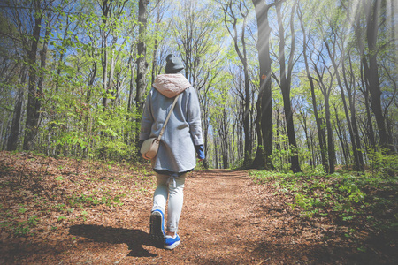 年轻女子独自行走在早春森林