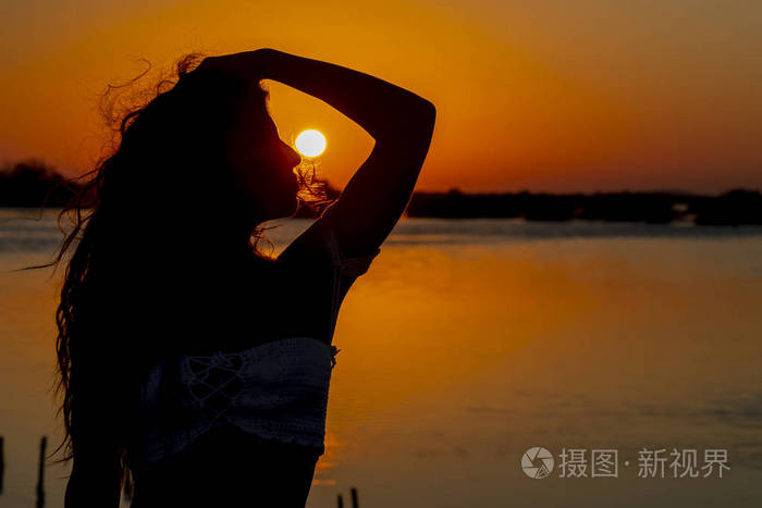 美丽的西班牙黑发模特在日出时享受清晨的阳光