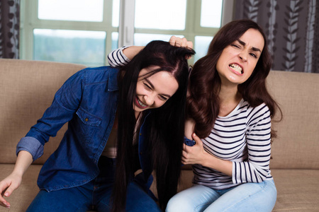 抢夺两个好斗的年轻女子打架, 互相抢夺头发照片