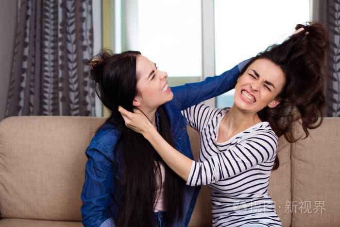 两个好斗的年轻女子打架互相抢夺头发