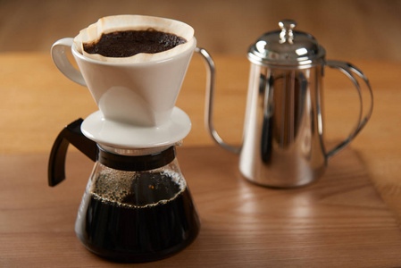 陶瓷手滴咖啡壶 滴头 和滴水地面咖啡在玻璃服务器上, 不锈钢滴锅
