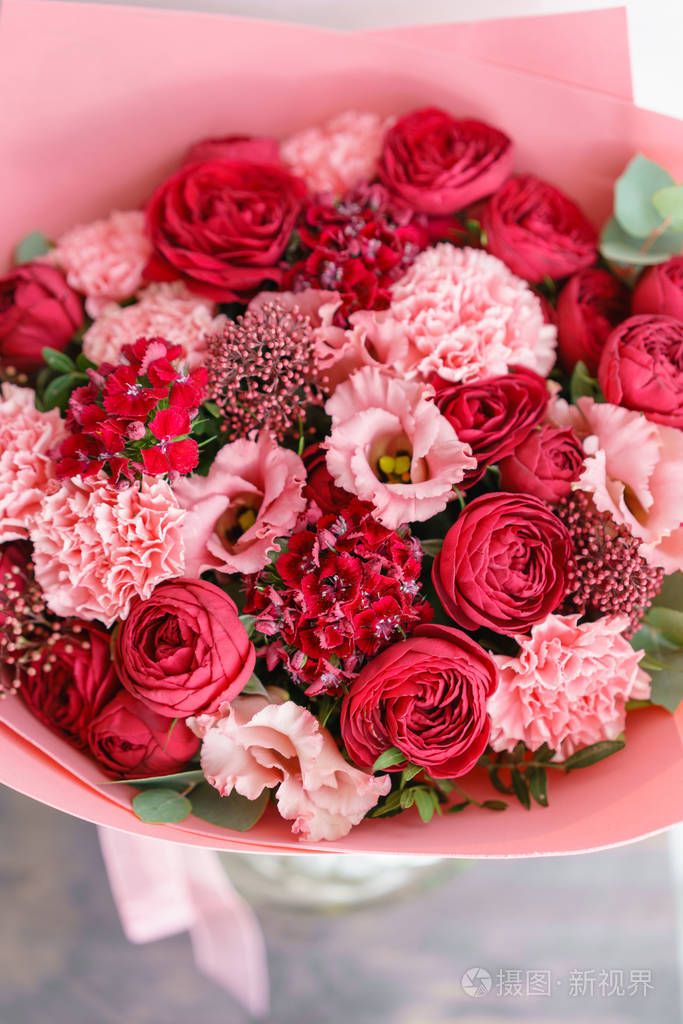 在木桌上的美丽的花朵鲜艳的红色花束.植物概念.春天的颜色.