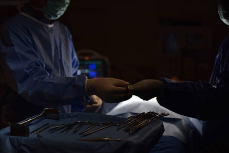 在手术室里工作的团队医生。手术室里的手术灯为外科手术的开始和切口做准备。外科医生正在对病人进行手术。