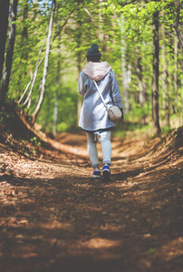 年轻女子独自行走在早春森林