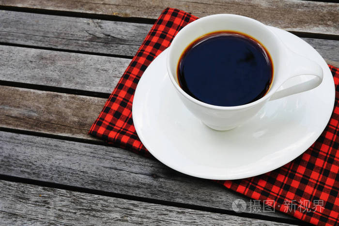 杯咖啡上用红色手帕木制背景和副本空间