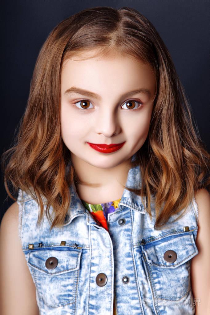 可爱的小女孩用红红的嘴唇在工作室里摆姿势