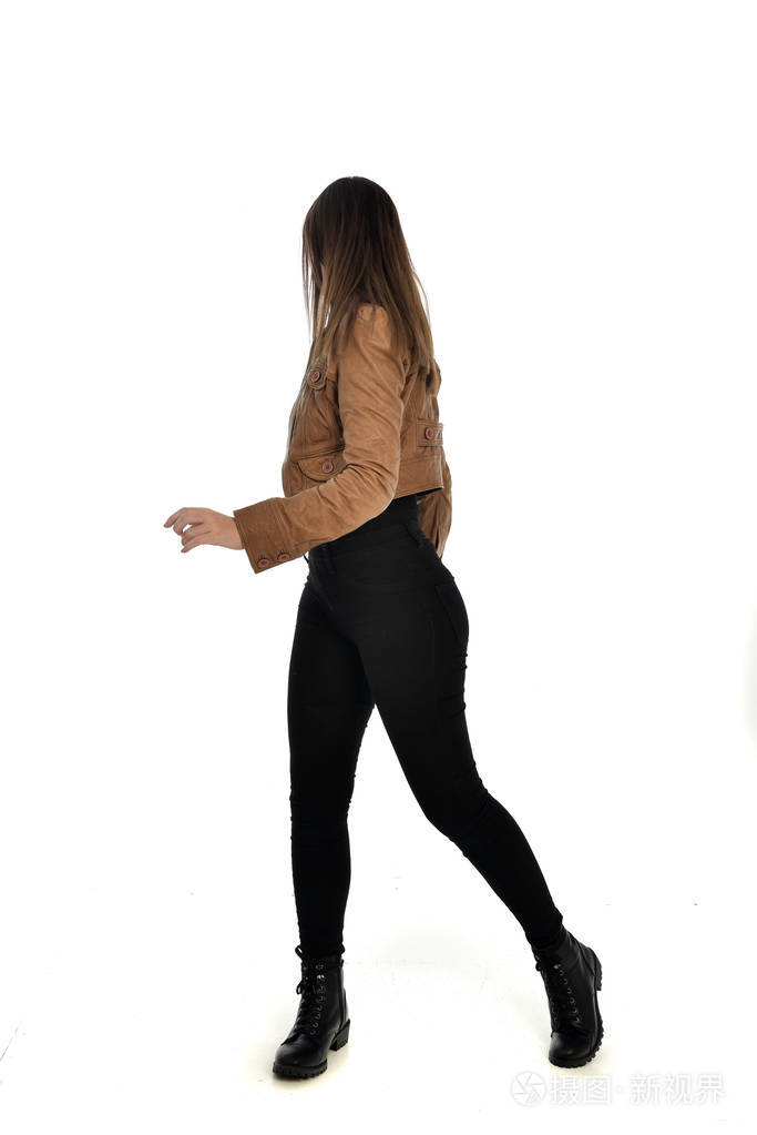 穿着棕色皮夹克的黑发女孩的全长肖像.在白色背景上站立姿势