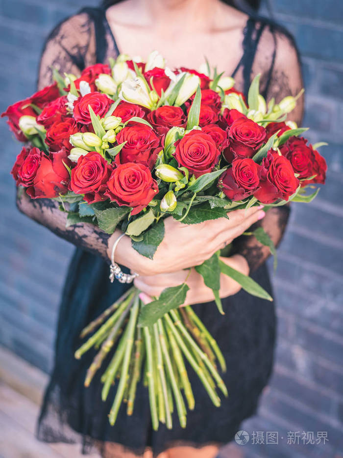 手捧着一束红玫瑰, 庄稼