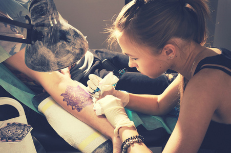 一只手上显示创作纹身过程女人纹身大师的画像