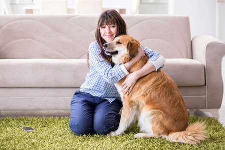 快乐的女狗主人在家中与金猎犬