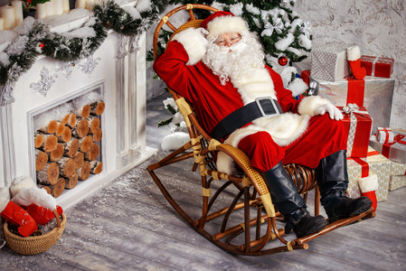 圣诞老人在摇椅上可爱的小狗坐在木制摇椅上男人在摇椅上休息, 咖啡被