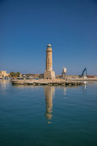 港口和灯塔的雷斯城在克里特岛的希腊, 与船只, 反射在海浪的海洋和云