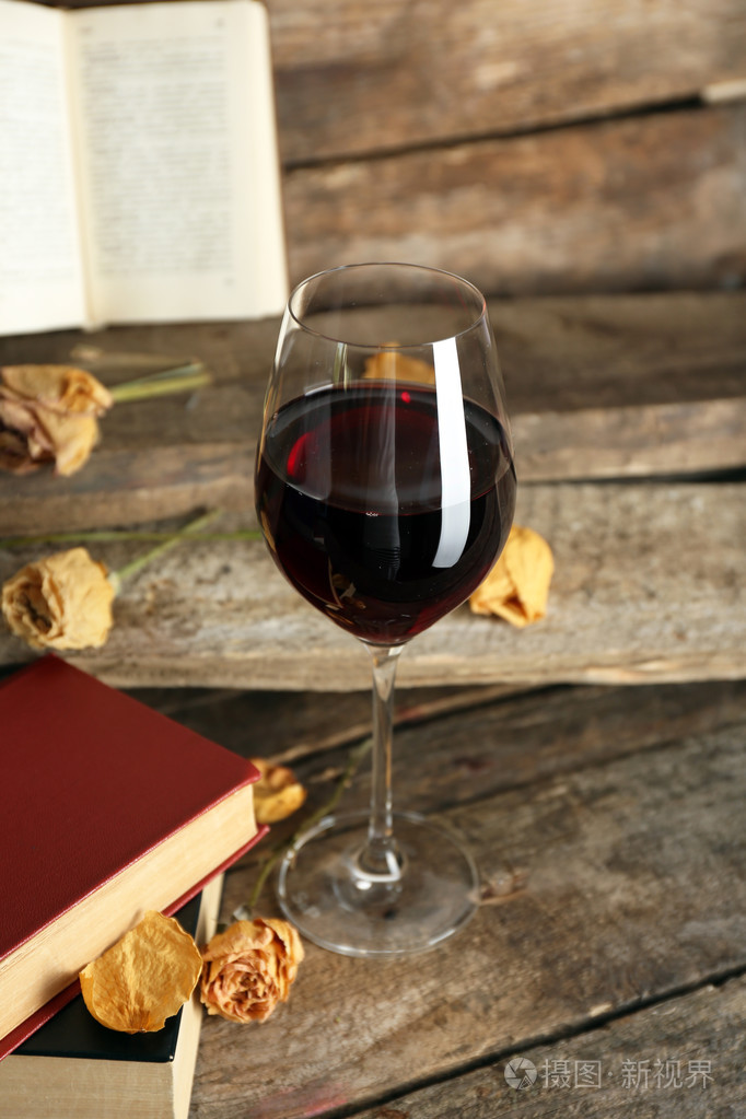美丽的组成与杯红酒的桌子上的老书关闭