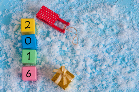 新的 2016 年木上雪 雪橇 礼物和空空间的文本颜色木多维数据集的数字。新年快乐概念明信片