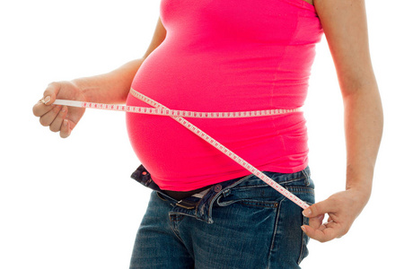 孕妇用胶带隔离在白色背景上衡量她的肚子