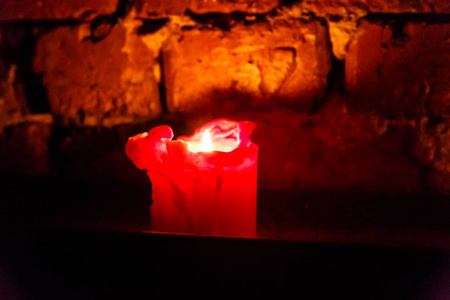 蜡烛在旧砖墙的背景上燃烧