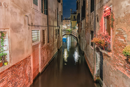 观看风景如画的运河和小桥在晚上在威尼斯的圣马球区, 意大利