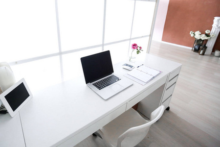 现代的室内工作场所与笔记本电脑在白色的颜色