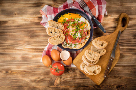 自制早餐煎鸡蛋, 西红柿放在木桌上。顶部视图