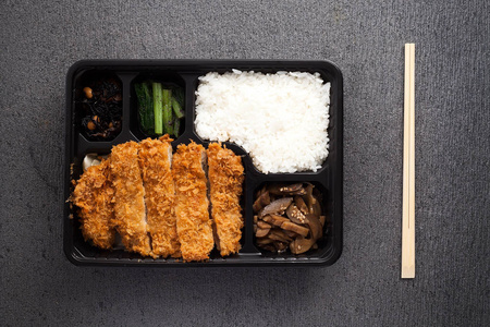 日本食品炸猪排饭和蔬菜带走在表格背景